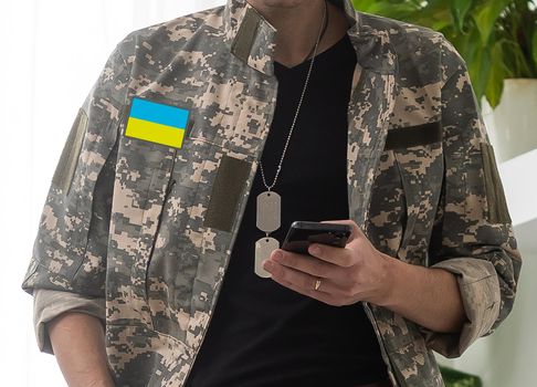 Ukrainian man warrior dressed in a military pixel uniform the yellow-blue flag of Ukraine