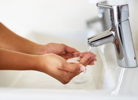 Stay healthy by washing your hands. Cropped shot of a young woman washing her hands.