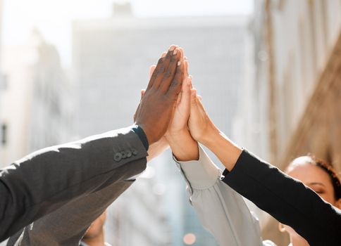Teamwork will make our dream work. Shot of a group of businesspeople high fiving one another.