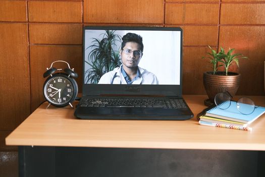 young asian doctor on laptop screen in video chat.