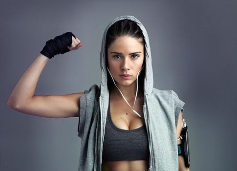 I have more than core strength. Studio shot of a sporty young woman against a gray background.