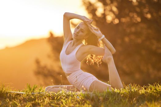 Full length shot of an attractive young woman practicing yoga outside on a sunny morning.