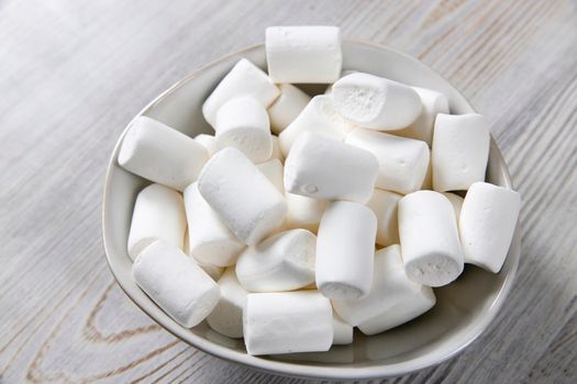 White marshmallows in a porcelain bowl on the table