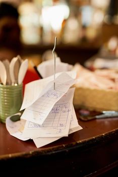 Everything in its place. Shot of slips on a receipt holder in a restaurant.