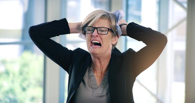I dont see an end to this challenge. Shot of a mature businesswoman looking stressed out in an office.