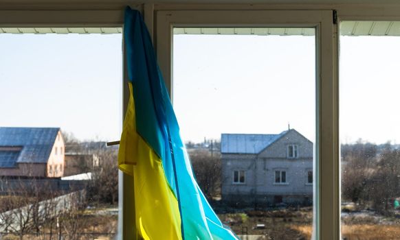 Flag of Ukraine on the window sealed with tape. No war. War in Ukraine