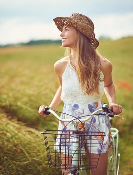 Its a beautiful world, get out there and discover it. Shot of a young woman cycling through the countryside.