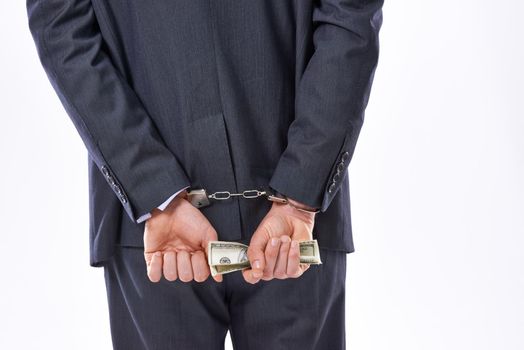 Fail with honor instead of succeeding with fraud. Rear view studio shot of a businessman in handcuffs holding American Dollars.