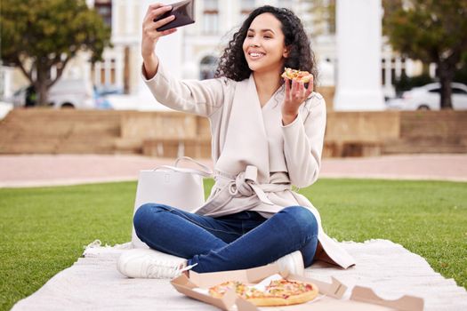 Break time is pizza time. Shot of an attractive young female university student taking selfies outside on campus during her break.