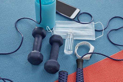 Healthy isnt a goal, its a way of living. Studio shot of a variety of workout equipment and PPE on a red and blue yoga mat.
