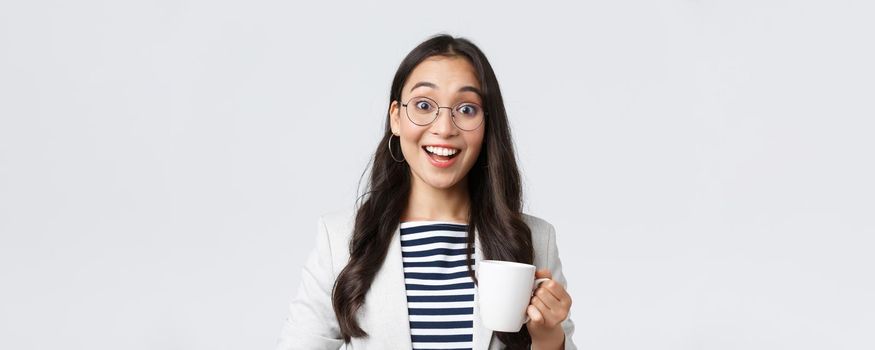 Business, finance and employment, female successful entrepreneurs concept. Close-up of outgoing smiling asian office worker talking to coworker at office kitchen, drinking coffee