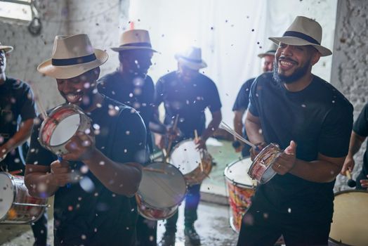 In sync to Brazilian beats. Shot of a group of musical performers playing together indoors.