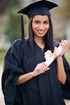 Shes destined for success. Portrait of a young woman holding her diploma on graduation day.