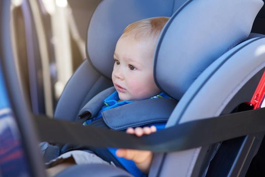 Cropped shot of an adorable baby boy sitting in a car seat.