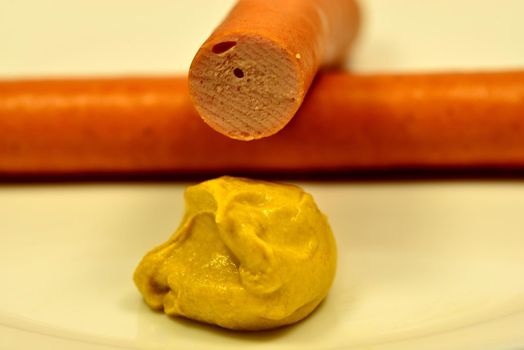 Wiener sausage with mustard in a closeup