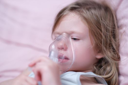 Little girl making inhalation of hormonal drug using nebulizer