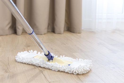 Modern white mop cleaning a wooden floor