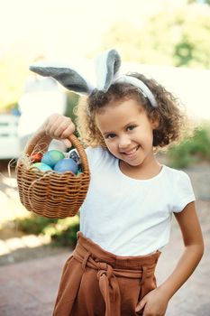 I cant wait to stuff my face. Shot of a girl carrying a basket of easter eggs.