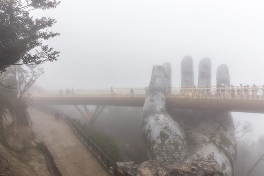 Danang , Vietnam - JANUARY 04, 2019 : View in Fog of the Golden Bridge on Ba Na Hills in Da Nang on rainy day