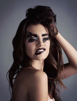 Makeup is art. Beauty is spirit. Studio shot of an attractive young woman wearing bold makeup.