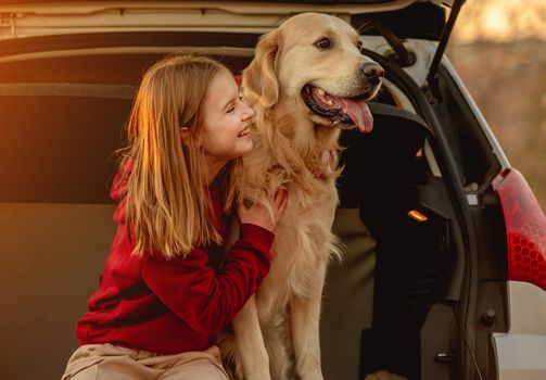 Girl with golden retriever dog in car