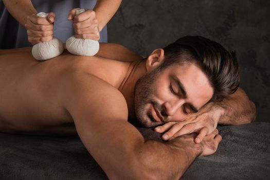 Man having back massage with pouche