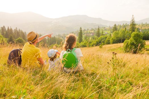 Free family looking at landscape travel Ukraine. Pointing family mountain vacation time together travel child and parents and kids. Hiking family vacation holiday summer travel local trekking mountain