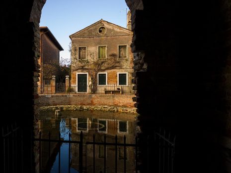 Italian dwelling through arched masonry passageway in Torcello