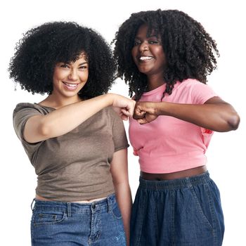 A friend like her is hard to find. Studio shot of two young women bumping fists against a white background.