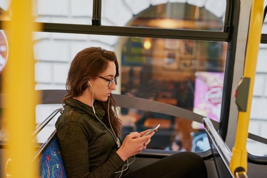 High angle shot of an attractive young woman listening to music while sitting on a bus.