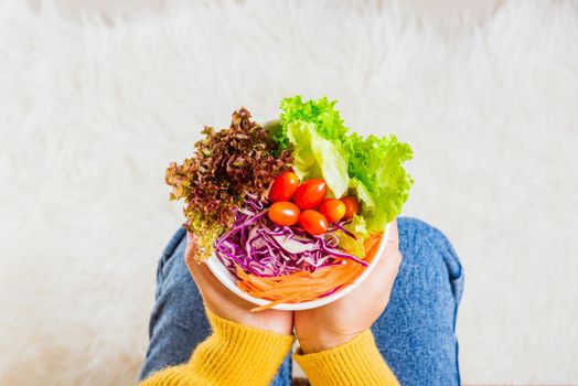 Female hands holding bowl with green lettuce salad