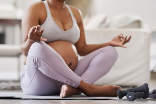 A calm momma= A peaceful baby. Cropped shot of a pregnant woman doing yoga at home.