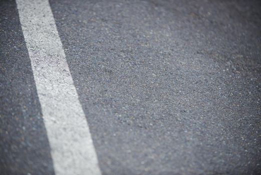 Hit the road. Closeup shot of a white dividing line on an asphalt road.