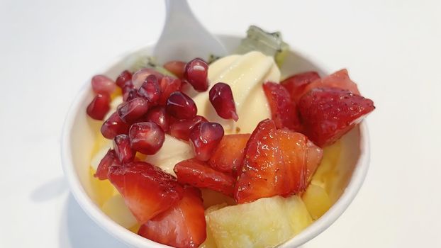Close up frozen yogurt with mixed fruit in small bowl
