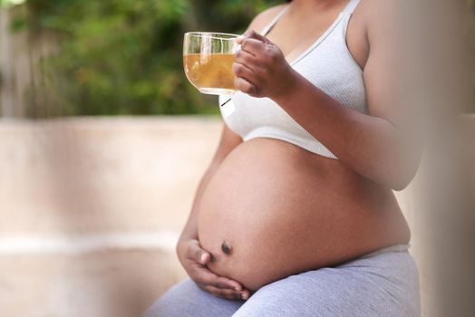 If itll benefit my baby, Im doing it. Cropped shot of a pregnant woman drinking tea while wearing exercise clothes.