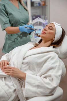 Cosmetologist making aesthetic face treatment in beauty salon. Rejuvenation and hydration