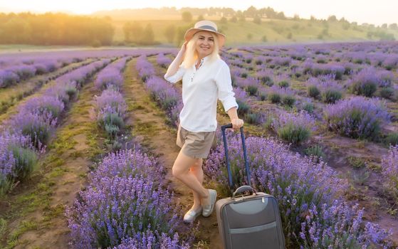 woman with luggage in lavender field