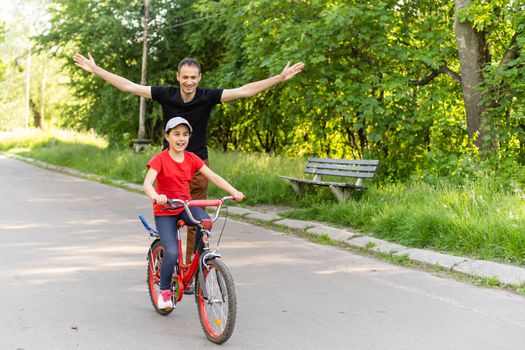 happy family father teaches child daughter to ride a bike in the Park in nature