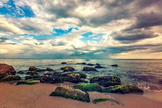 Stone beach. Day view of sea with dramatic sky and clouds. Nature landscape.
