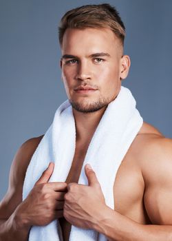 My skin is healthy and protected against dryness. Shot of a handsome young man posing with a towel around his neck.