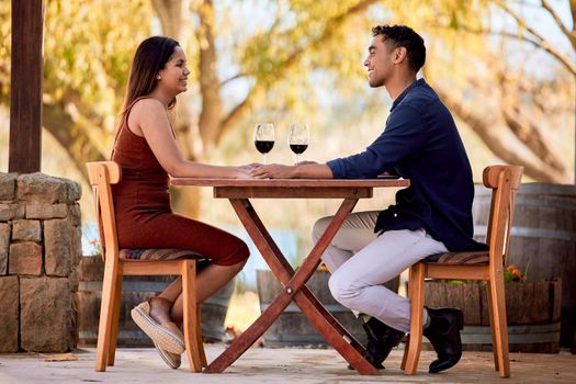 Love the feeling of getting glammed up to go out with my sweetie. Shot of a young couple having wine on a date on a wine farm.