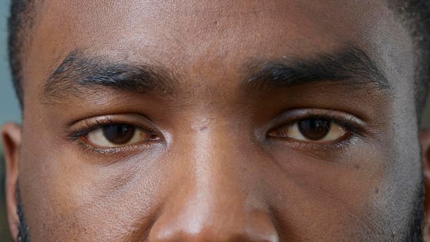 Macro shot of young man showing brown eyes on camera