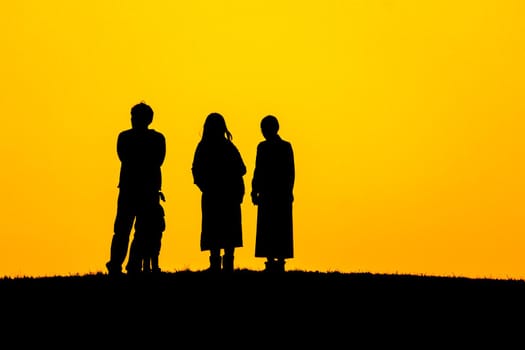 Silhouette of people sitting on the hill at dusk. Shooting Location: Mitaka City, Tokyo