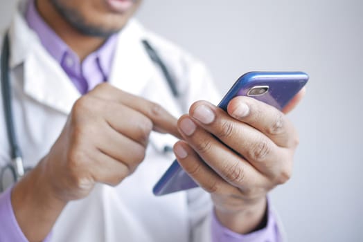 doctor in white coat using a smartphone.