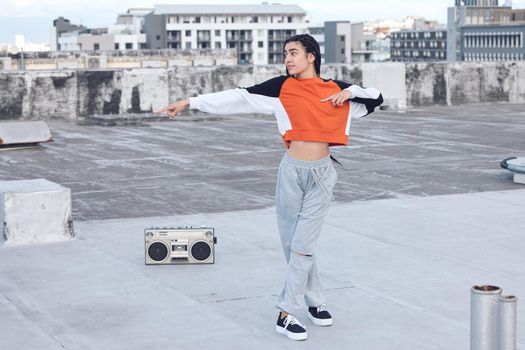 I came, I saw, and I nailed it. Shot of a young woman out on a rooftop with a boombox.