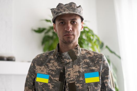 Ukrainian man warrior dressed in a military pixel uniform the yellow-blue flag of Ukraine