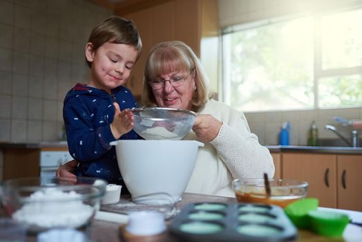 Baking fun with gran. Cropped shot of a woman baking with her grandson at home.