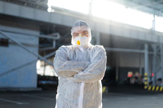COVID-19 coronavirus doctor standing hospital parking dressed white protective overalls hazmat suit.