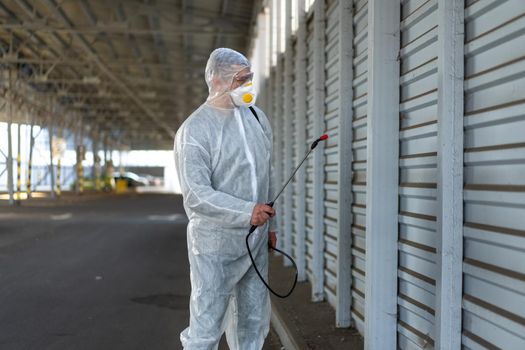Worker wearing protective suit disinfection gear disinfect surface public place