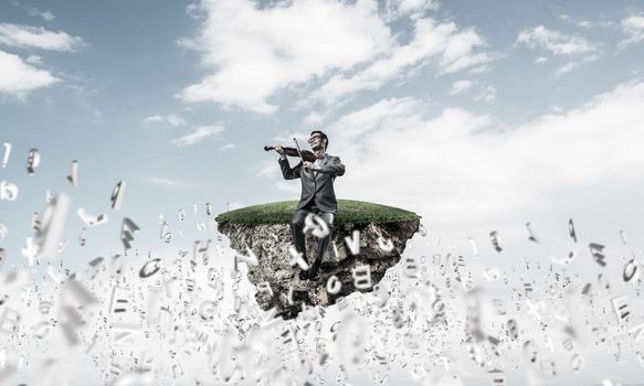 Handsome violinist play his melody and letters fly around in air